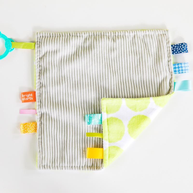 BRIGHT STARTS Maznacia dečka na C krúžku Little Taggies zelené bodky 0m+